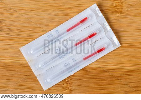 A Top Down Portrait Of Long Tin Single Wrapped Acupuncture Needles Still In The Package, Ready To Us
