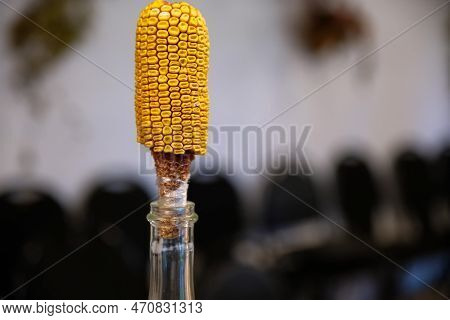 Glass Bottle Of Moonshine Close Up. A Cob Of Corn As A Stopper Of A Bottle.