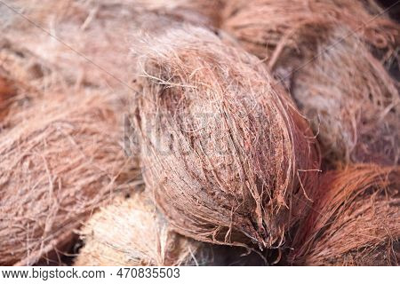 Close-up On A Stack Of Dehusked Coconut Fruits On A Market Stall.