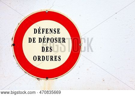 Sign Screwed On A White Painted Wall Stating In French 