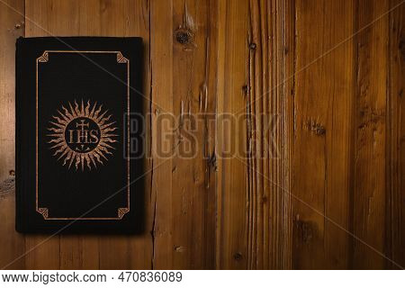 Close-up On Black Christian Book With A Gilded Christogram Of The Society Of Jesus (founded In 1540)