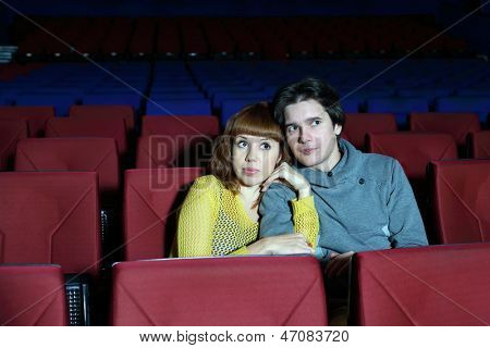 Giovane uomo e Guarda il film donna, abbraccio e paura nel teatro cinema.