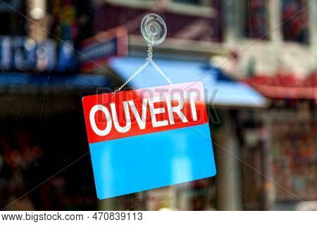 Red And Blue Sign In The Window Of A Shop Saying In French 