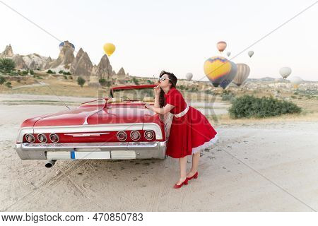Beautiful Girl In Retro Style Posing Near A Vintage Red Cabriolet Car On Background Of Balloons In C