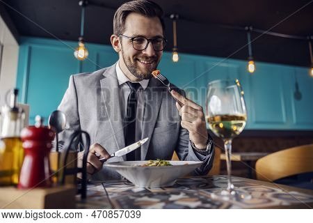 The Man Is About To Take A Bite Of Food, The Man Has Lunch At A Restaurant. A Man Elegantly Dressed 