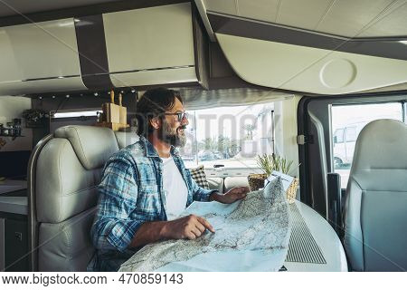 Happy Mature Man Smilng Inside A Camper Camping Car Using Paper Map Guide To Plan Destinations Holid