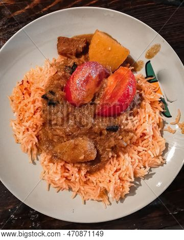Tomato Onion Rice, Tamatar Biryani On A Black Plate On A Dark Wooden Table, Horizontal View From Abo