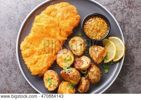 Delicious German Munich Schnitzel Fried Breaded With Mustard And Horseradish Served With Baked Potat