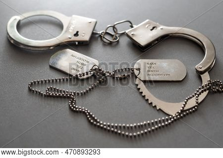 A Military Badge And Handcuffs On A Dark Background