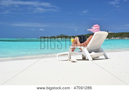 Dívka s notebookem na tropické pláži. Exuma, Bahamy