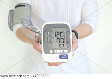 Man Checks Blood Pressure Monitor And Heart Rate Monitor With Digital Pressure Gauge. Health Care An