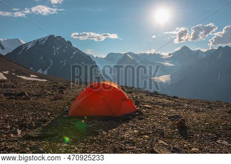 Awesome Alpine Landscape With Orange Tent With View To High Snow Mountains And Large Glacier. Bright
