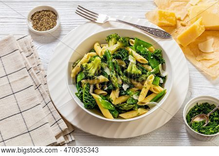 Pasta Primavera With Asparagus, Snap Peas, Broccoli And Kale In White Bowl, On White Wood Table