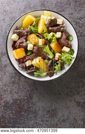 French Hot Salad With Gizzards Or Salade Chaude Aux Gesiers Close-up In A Plate On The Table. Vertic