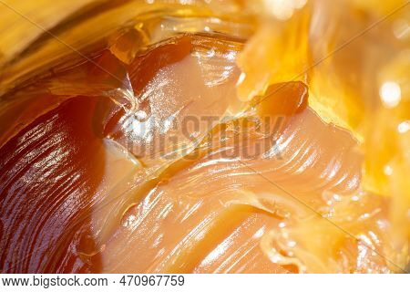 Close Up Shot Of Anti-friction Multi-purpose Waterproof Grease. Yellow Orange Machinery Oil Under Su