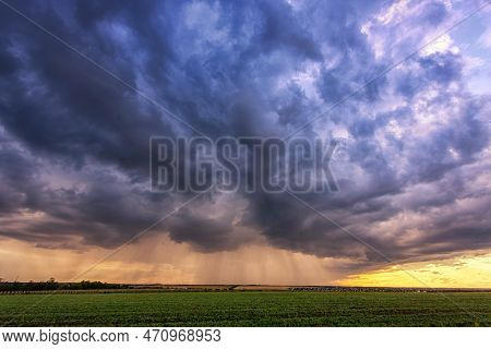 Storm Clouds Over A Green Field At Sunset, Rain