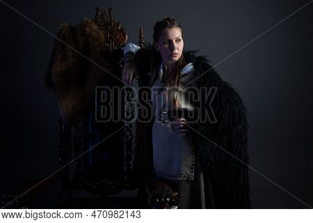 An Authoritative, Self-confident Woman In A Viking-style Fantasy Costume. Leaning On A High Chair. S