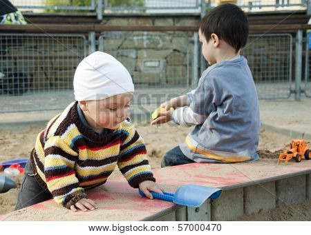 Children Playing With Sand At Playground
