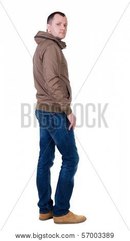Back view of handsome man in brown windcheater looking up.   Standing young guy in jeans. Rear view people collection.  backside view of person.  Isolated over white background.