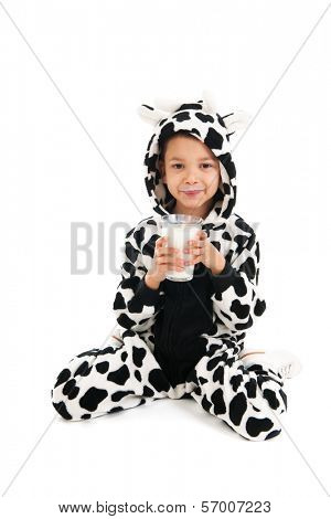 Little boy dressed as cow drinking healthy glass of milk