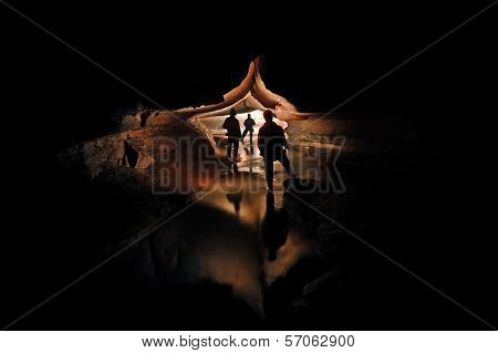 Spelunkers Exploring An Underground Cave River