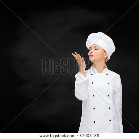 cooking, gesture and food concept - smiling female chef showing delicious gesture
