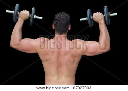 Strong crossfitter lifting up heavy black dumbbells on black background