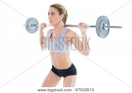 Strong female crossfitter lifting barbell behind head on white background