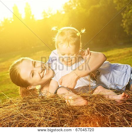 Happy Family In Summer Nature. Mother And Baby Daughter On Hay