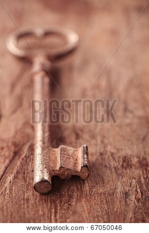 large and small rusty vintage metal keys on old wooden background, shallow dof