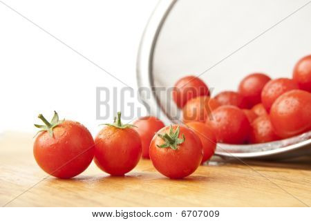 Gewassen tomaten In vergiet op snijplank
