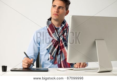 Graphic designer using graphics tablet to do his work at desk 