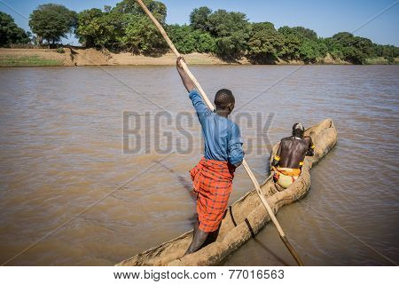 Men Cross The Omo River Near Turmi Using A Wooden Boat, Ethiopia.