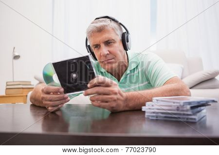 Mature man listening to cds at home in the living room