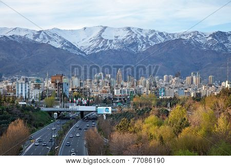 Tehran Skyline And Highway In Front Of Snowy Mountains