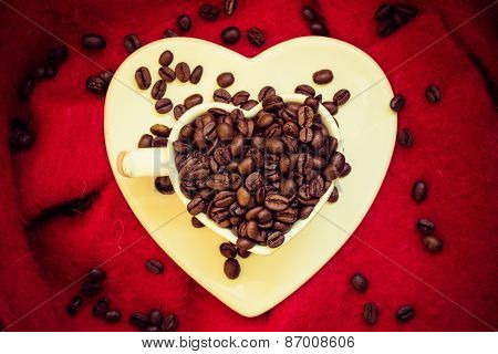 Heart Shaped Cup With Coffee Beans On Red
