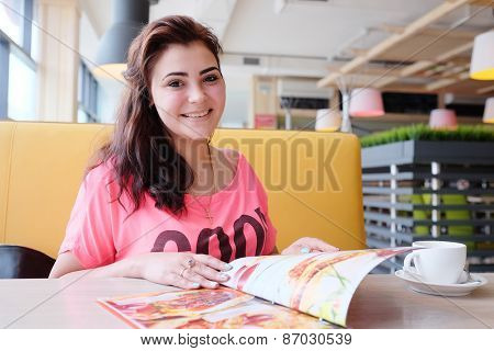 Pretty woman looking at the menu at a restaurant 