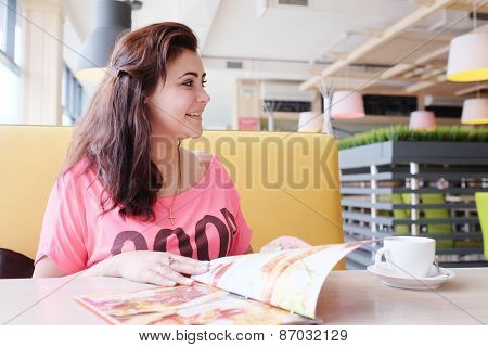 Pretty woman looking at the menu at a restaurant 