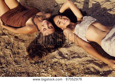 Photo Of Two Beautiful Girls With Dark Hair Lying On Beach
