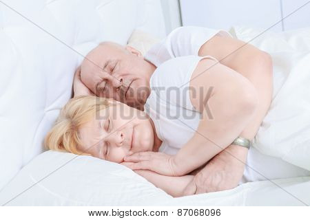 Elderly couple asleep in bed