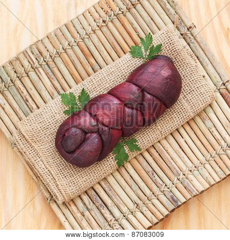 Treccia - Braided Mozzarella Cheese Marinated In Red Wine On Sackcloth On Wooden Board