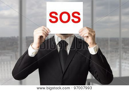 Businessman Hiding Face Behind Sign Sos