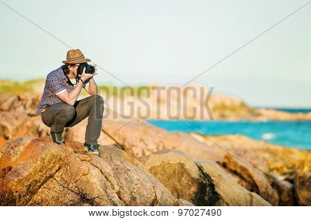 Young photographer taking photos at the beach