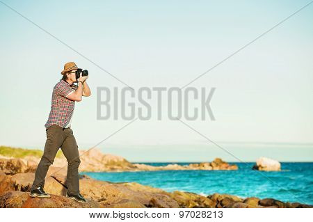 Young photographer taking photos at the beach
