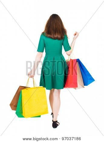 back view of going  woman  with shopping bags . beautiful girl in motion.  backside view of person.  Isolated over white background. girl in stylish green dress is holding shopping bags on bent elbow
