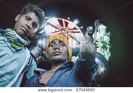 JODHPUR, INDIA - 08 FEBRUARY 2015: Young Indian boys work as light holders in bride-grooms wedding procession. Post-processed with grain, texture and colour effect.