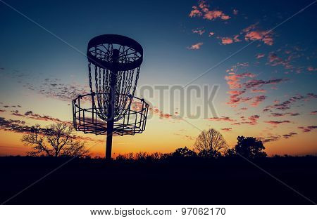 Silhouette Of Disc Golf Basket Against Sunset