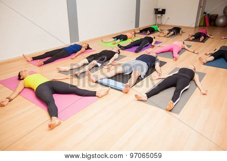 Group Of People Lying Down In Yoga Class
