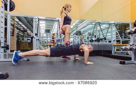 Woman coach training a man with hard push ups