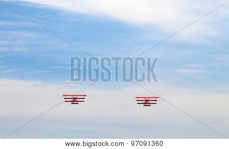 Ancient Red Triplanes Fly In The Blue Sky